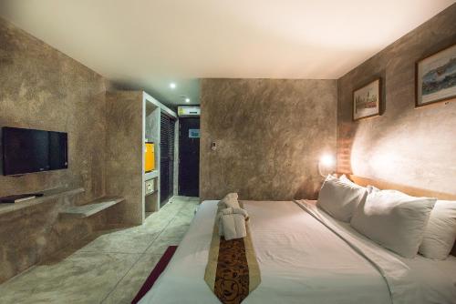 a bedroom with a bed with a teddy bear on it at Buddy Boutique Inn in Bangkok