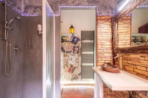 a bathroom with a shower and a stone wall at ZAMBONI House Deluxe in Bologna