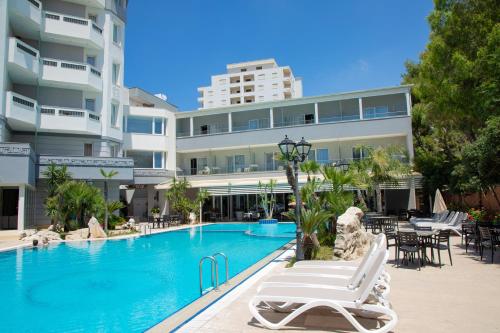 un hotel con piscina frente a un edificio en Hotel Dyrrah en Durrës