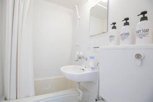 a white bathroom with a sink and a mirror at 閑静な住宅街_暖かく居心地の良いデザイン SoW-2 in Tokyo