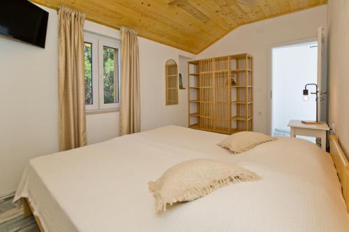 um quarto com uma grande cama branca e uma janela em Robinson house T'n'T em Hvar