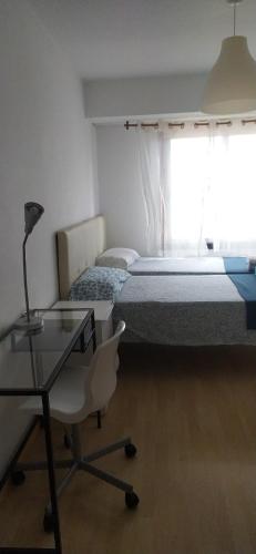a bedroom with a bed and a desk and a chair at A Coruña Sky Blue Rooms cerca playa riazor in A Coruña