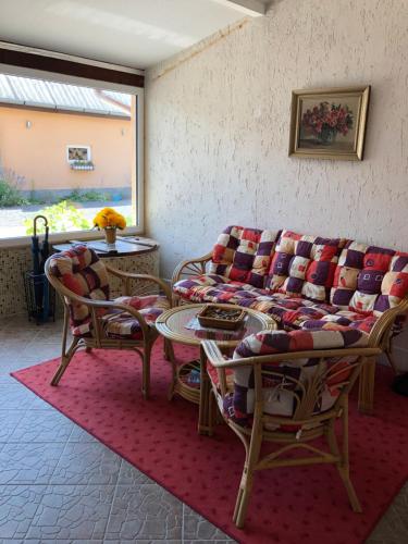un soggiorno con divano, sedie e tavolo di Panoráma Apartman Felsötárkány a Felsőtárkány