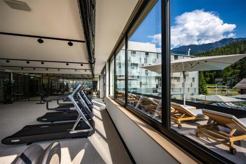a balcony with lounge chairs and a view of a building at Arena Franz Ferdinand Nassfeld in Tröpolach