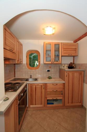a kitchen with wooden cabinets and an arched ceiling at Holiday Home Vesna in Brod na Kupi