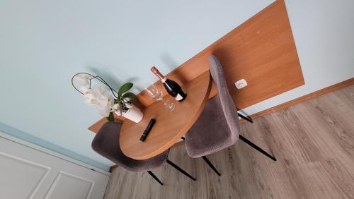 a wooden table with two chairs and a vase of flowers at Willa Wladek in Władysławowo