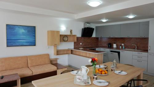 een keuken en een woonkamer met een houten tafel bij вила Ема Балчик - villa Ema Balchik in Balchik