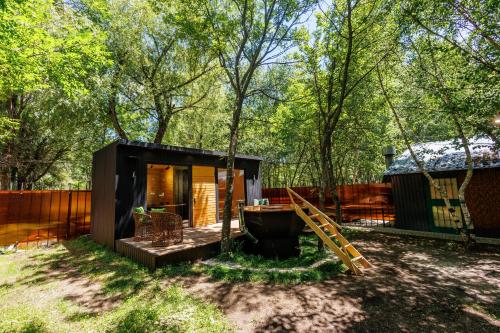 a small black tiny house in the woods at Garden Inn Resort Sevan in Sevan