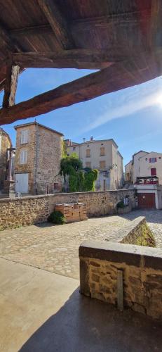 a stone bench sitting in a courtyard with buildings at La maison du vigneron in Auzon