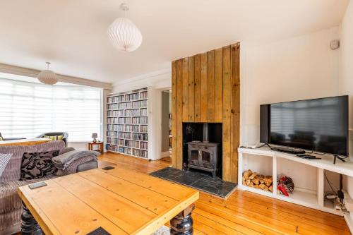 a living room with a couch and a table and a tv at Seaview in Mundesley