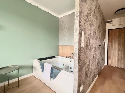 a bath tub in a bathroom with green walls at Gold Sleep nowy apartament z jacuzzi na wyłączność in Wrocław