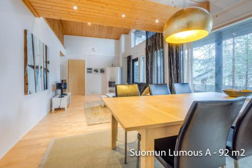 comedor con mesa de madera y sillas en Holiday Apartments Suomun Lumous en Suomutunturi