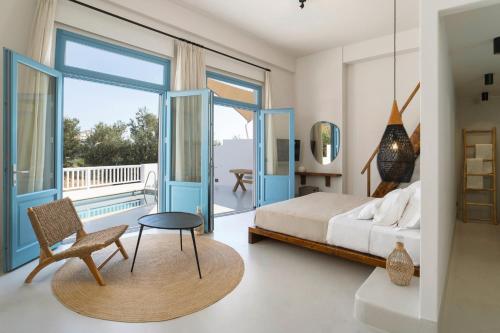 a bedroom with a bed and a balcony at Andros Moments Suites in Batsi