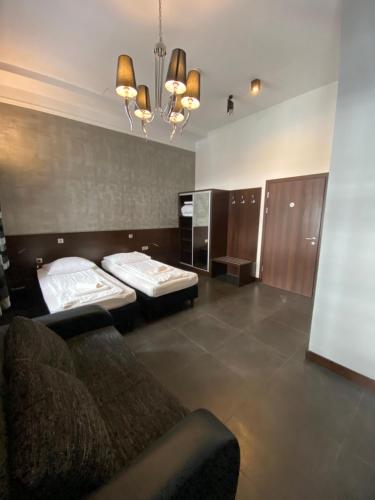 a living room with two beds and a couch at Aparthotel Łódź 55 Piotrkowska in Łódź