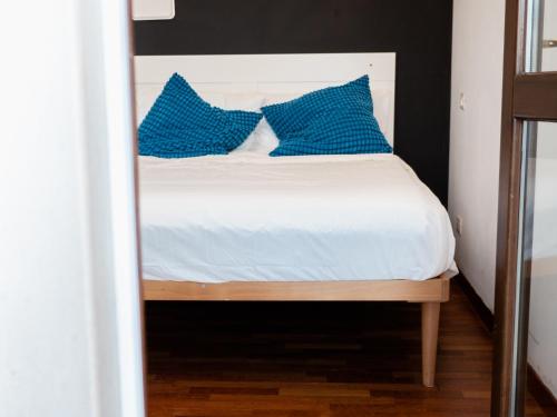 um quarto com uma cama com almofadas azuis em Minià em Pescara