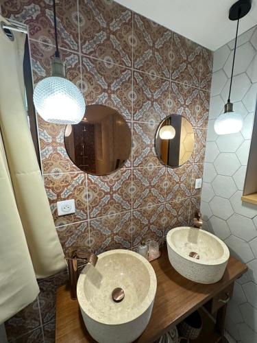 ein Badezimmer mit 2 Waschbecken und einem Spiegel in der Unterkunft Ô Trois Puits in Laburgade