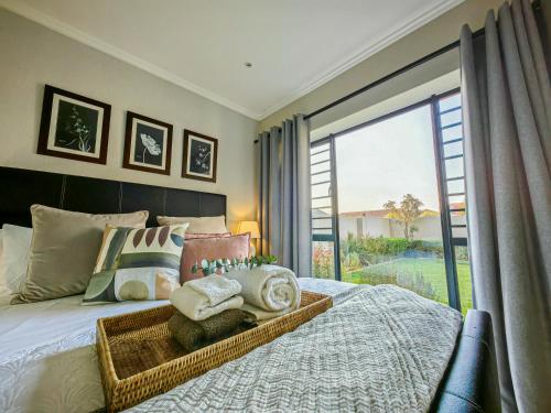 Schlafzimmer mit einem Bett und einem großen Fenster in der Unterkunft Garden Unit Inverter,nespresso,blender,netflix in Johannesburg