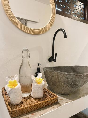 a bathroom counter with a sink and a mirror at Adi's Bungalow in Uluwatu