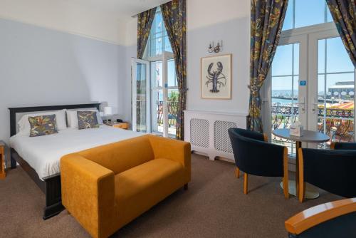 Habitación de hotel con cama, mesa y sillas en Hotel Rex, en Weymouth