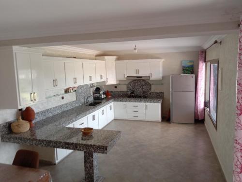 a kitchen with white cabinets and a counter top at Ferme de Rayan in Safi