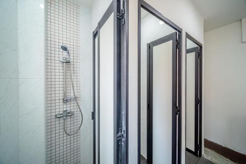 La salle de bains est pourvue d'une douche et d'une porte en verre. dans l'établissement K Space Inn 14, à Singapour
