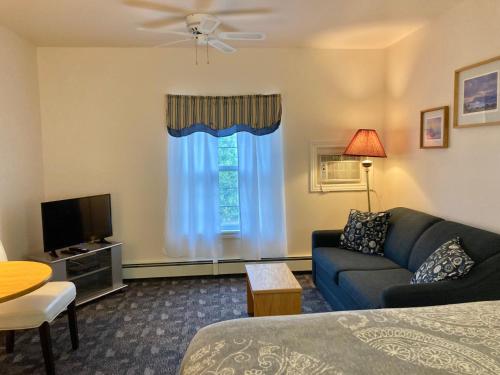a living room with a couch and a tv at Castle Rock Country Inn in Ingonish Beach