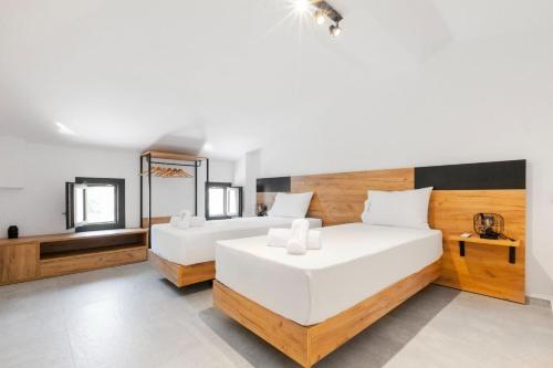 a bedroom with two white beds and a mirror at Villa Irene in Polychrono