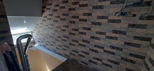 a bathroom with a brick wall with a shower at Guesthouse Next to beach in Batumi