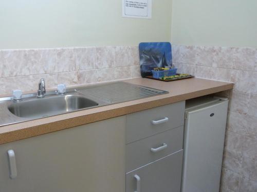 a kitchen with a sink and a counter top at Grand Central Motel in Mount Gambier