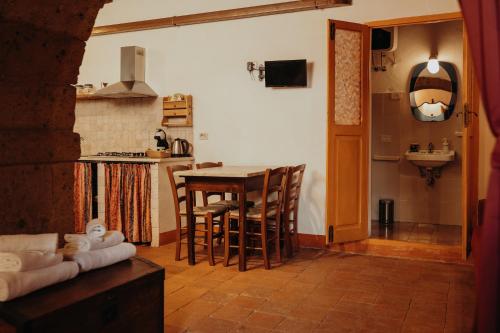 kuchnia ze stołem, krzesłami i zlewem w obiekcie Dolce Vita Assedio w mieście Pitigliano