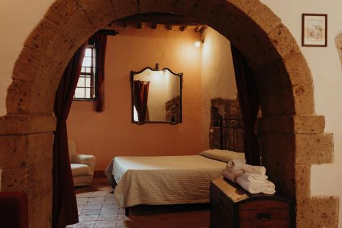 sypialnia z łóżkiem i łukiem w obiekcie Dolce Vita Assedio w mieście Pitigliano
