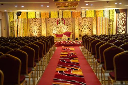 an empty hall with chairs and a red and yellow carpet at Hotel Newline Orchid in Guruvāyūr