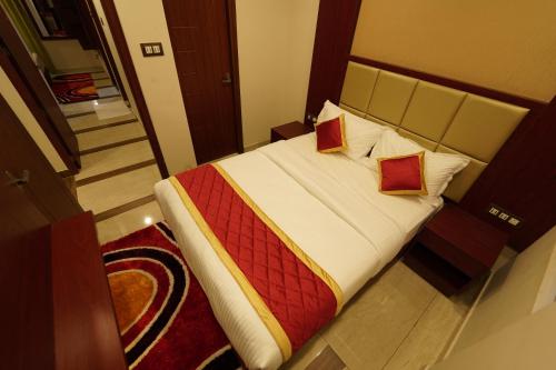 a bedroom with a large bed with two pillows at Hotel Newline Orchid in Guruvāyūr
