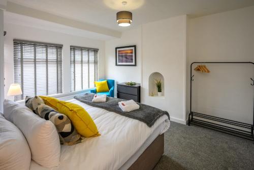 a bedroom with a large bed with yellow pillows at Frodo's Folly by StayStaycations in Port Talbot