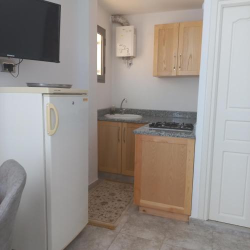 a kitchen with a white refrigerator and a sink at Residence djerba 1 in Houmt Souk