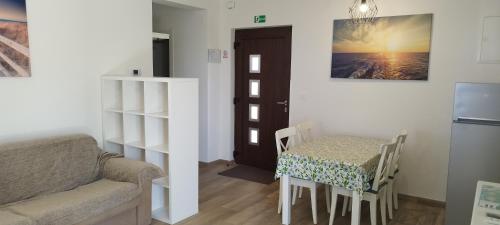 een woonkamer met een tafel, een stoel en een bank bij Apartments Villa Elma in Mošćenička Draga