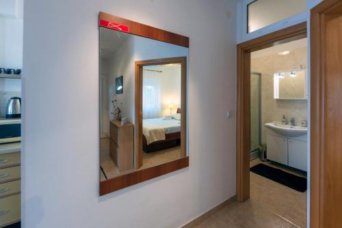 baño con espejo, cama y lavamanos en Apartment Anamaria with Seaview, en Petrčane