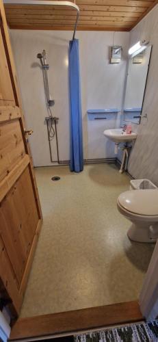 a bathroom with a shower and a toilet and a sink at Bungalåven Cottages & Rooms in Børselv