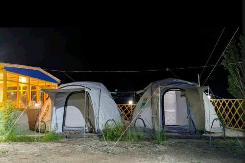 un grupo de tiendas de campaña en un campo por la noche en Baseet Camping and Restaurant, en Gulmit
