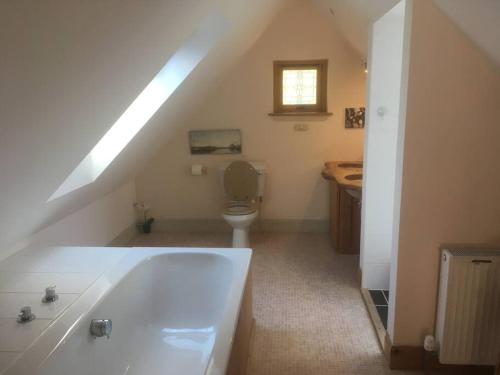 uma casa de banho com uma banheira branca e um WC. em The Neuk Achmore Plockton em Stromeferry