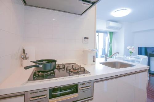 a kitchen with a stove with a pot on it at 10min walk to Shinjuku YEoE-2 in Tokyo