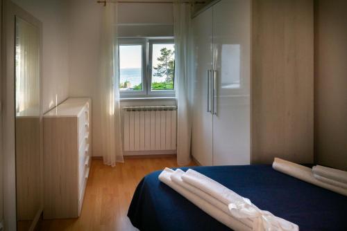 Un dormitorio con una cama azul y una ventana en Apartment Anamaria with Seaview, en Petrčane