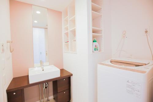 une salle de bain avec un lavabo et une laveuse et une sécheuse dans l'établissement 10min walk to Shinjuku YEoE-2, à Tokyo