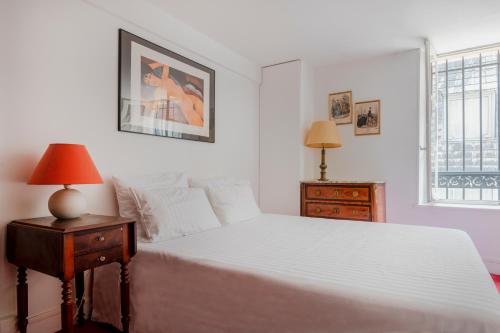 ein Schlafzimmer mit einem großen weißen Bett und einem Fenster in der Unterkunft Paris St Germain Charming in Paris