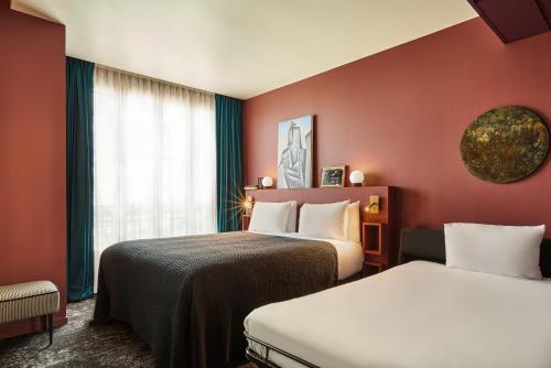 a hotel room with two beds and a window at Mercure Paris Tour Eiffel Pont Mirabeau in Paris