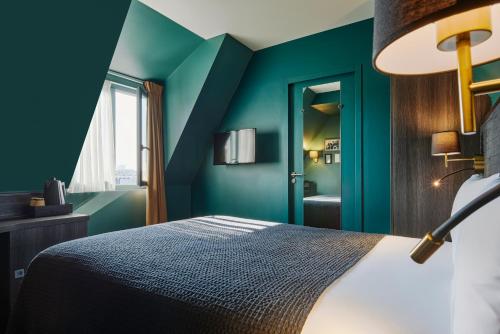 a bedroom with green walls and a bed with a lamp at Mercure Paris Tour Eiffel Pont Mirabeau in Paris