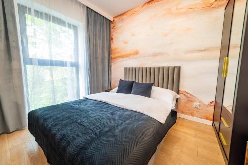 a bedroom with a bed and a large window at Lake Rental Spacerowa in Mikołajki