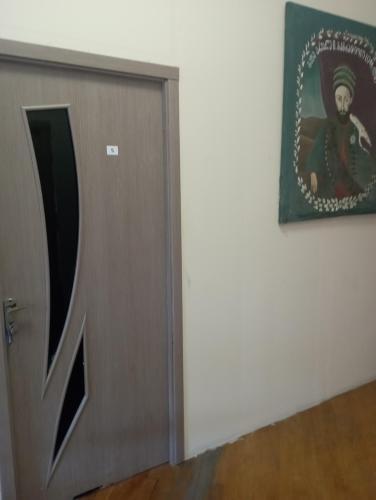 a door in a room with a picture on the wall at Art House Hostel Aleksandr in Kutaisi