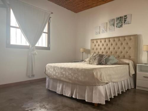 a bedroom with a large bed with a large window at La Puerta Azul San Carlos in San Carlos