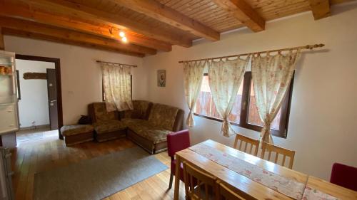 a living room with a couch and a table at Casuta din poiana Rau Sadului in Rau Sadului